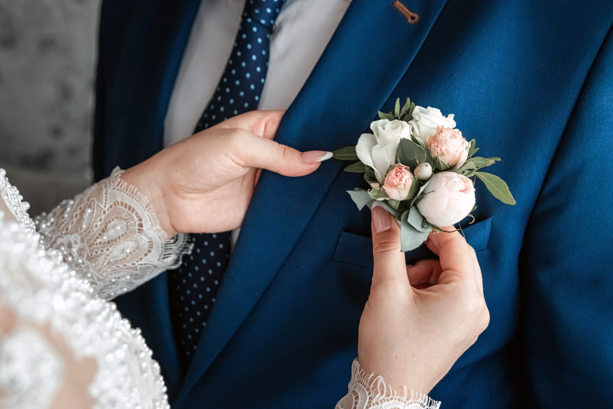 Bride pinning lapel flower wedding